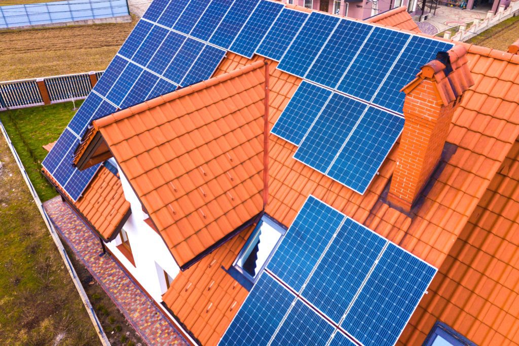 aerial top view new modern residential house cottage with blue shiny solar photo voltaic panels system roof renewable ecological green energy production concept